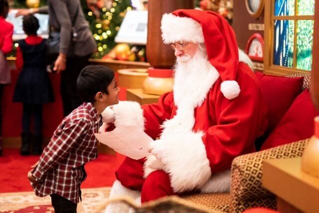 Santa reading a Christmas letter to a child