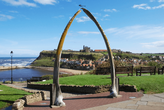 the Whitby Whalebone Arch with views of the coast in the background