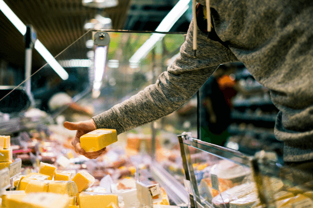 Person handing out cheese at Deli