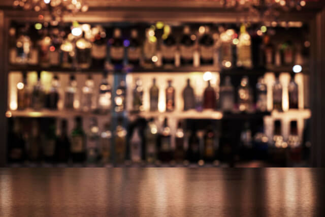 A blurry image of bottles on a shelf behind a bar