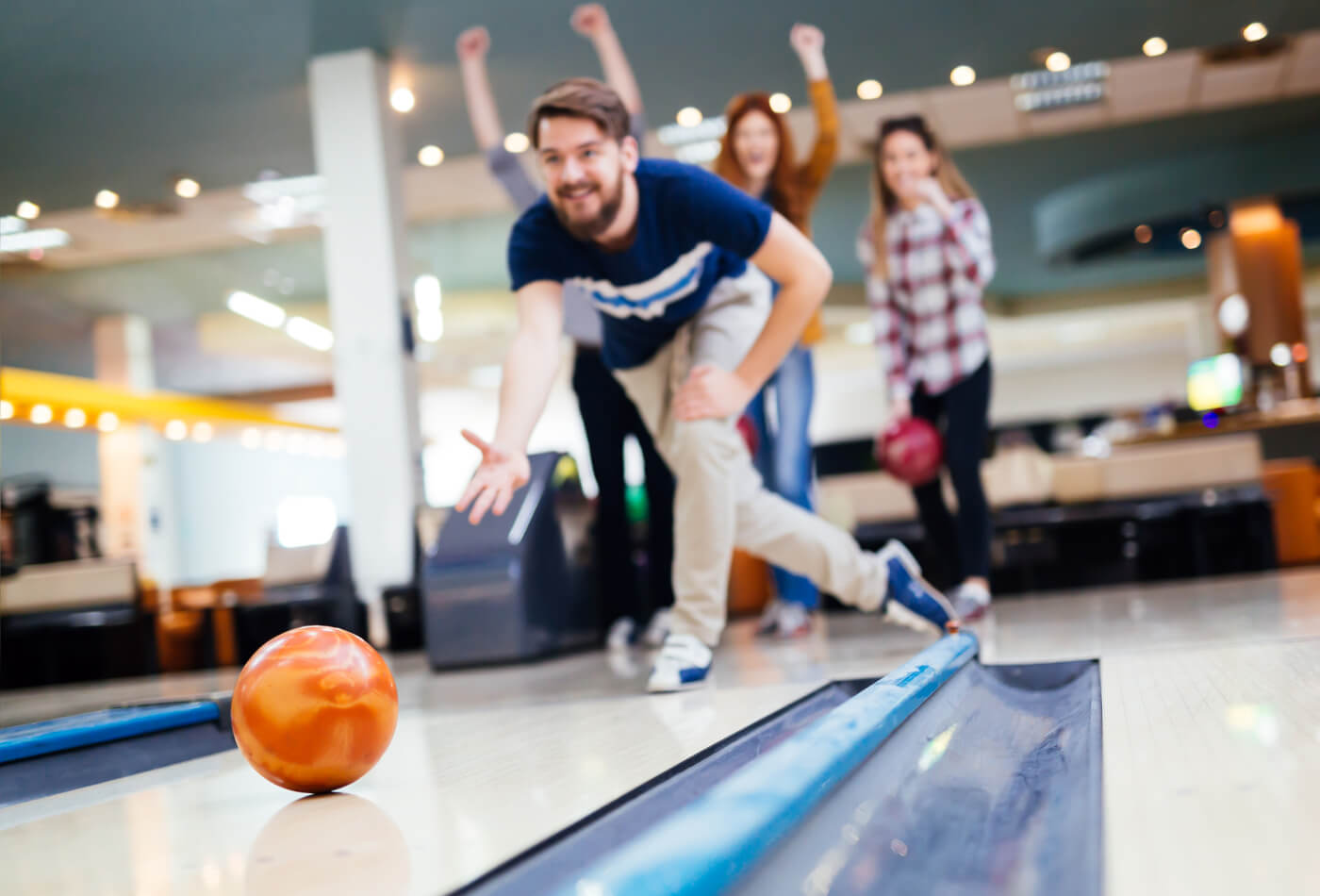 A group of four people bowling at a bowling alley