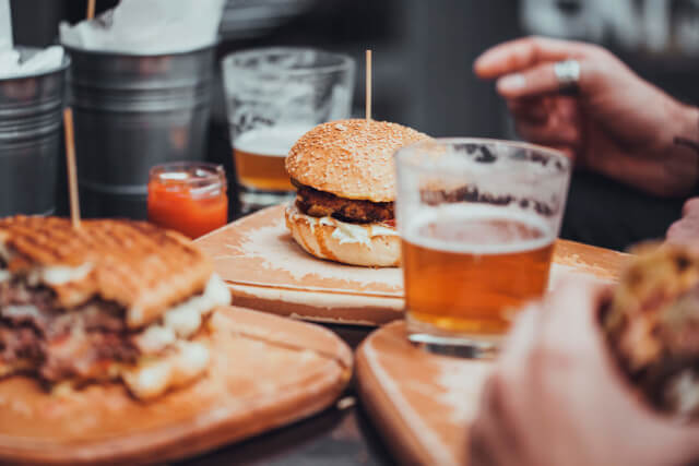 A plate of burgers and beers at a pub