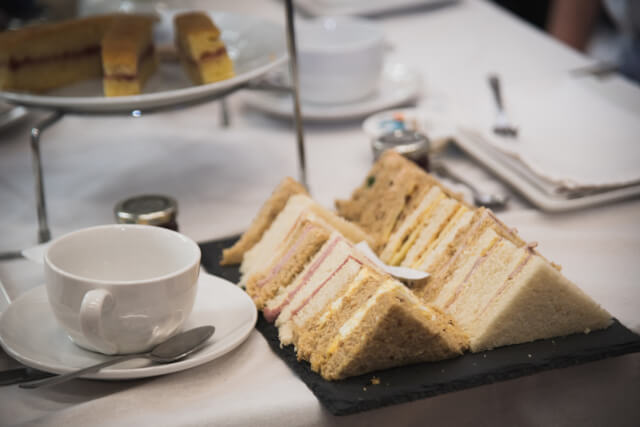 A plate of triangle sandwiches on an afternoon tea 