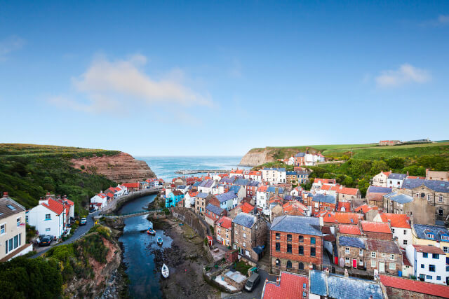 An ariel view above the rooftops of Staithes to the coast beyond