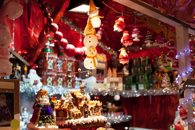 Christmas decorations hanging in a wooden stall at a Christmas market