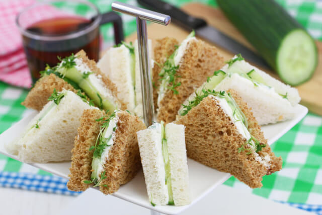 Triangle sandwiches on a plate at an afternoon tea