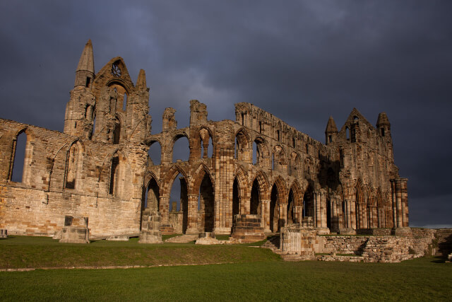 The ruins of Whitby Abbey with a stormy skin in the background