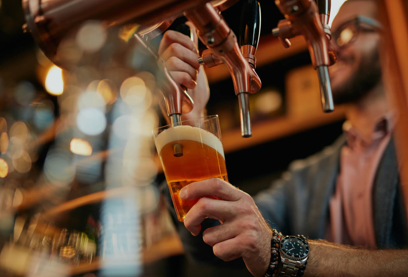 A barman pouring a pint behind a bar