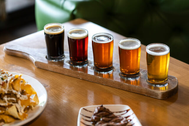 A paddle of sample size craft beers on a table in a pub