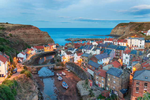 An elevated view across the rooftops of Staithes with a view of the sea beyond