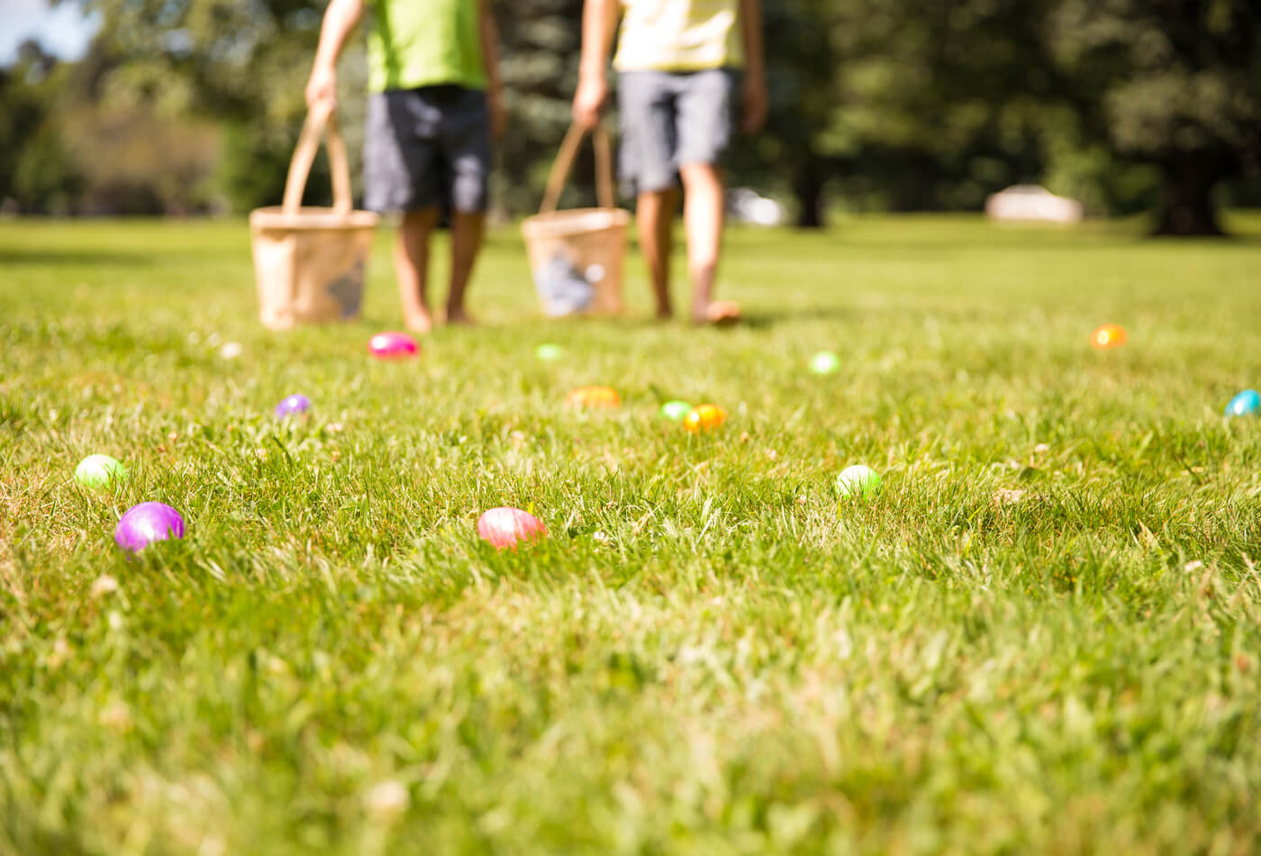 Children collecting colourful eggs in a field at easter